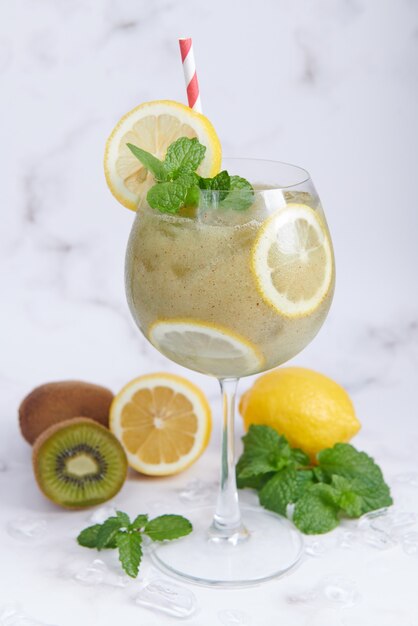 Frullati di kiwi freschi fatti in casa con limone, latte, menta e miele. Bevanda biologica sana. Primo piano e messa a fuoco selettiva. Frutta verde appena miscelata, benessere e concetto di perdita di peso.