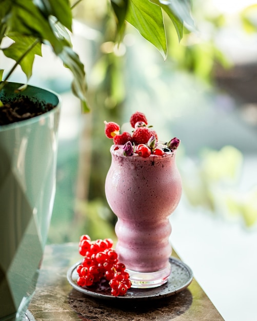 Frullato di bacche guarnito con lampone fragola e mirtilli rossi in spiedini di bambù