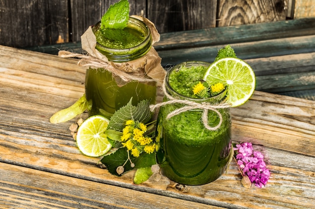 frullato verde in un barattolo con lime, kiwi e frutti di bosco