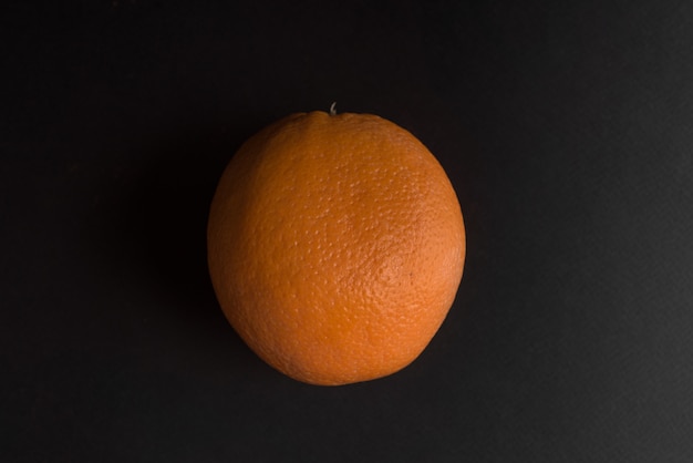 Frutta arancione fresca isolata sopra il nero