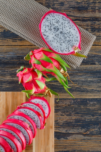 Frutta del drago con il tagliere sulla tavola di legno, vista superiore.