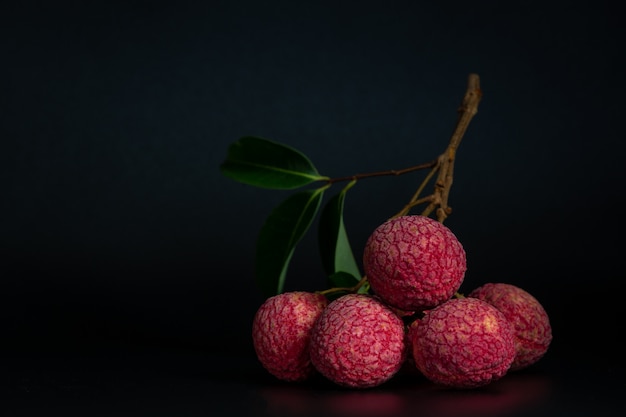 Frutta rossa del lychee disposta in un cestino.