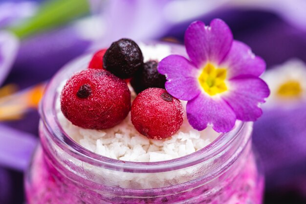Frutti di bosco dolci e condimenti floreali su un frullato vegano primaverile viola