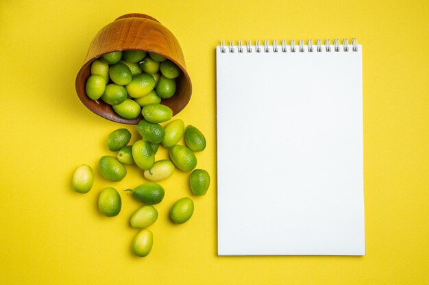 frutti in ciotola ciotola di frutta accanto al quaderno bianco e frutti verdi