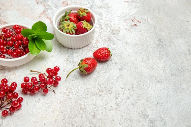 Frutti rossi di vista frontale con le bacche sulla frutta a bacca fresca rossa della tavola bianca