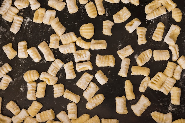 Full frame di gnocchi di pasta fatta in casa non cotti sul piano di lavoro della cucina