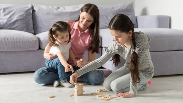 Full shot madre e bambini sul pavimento