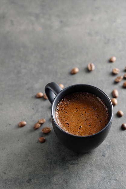 Fumante tazza di caffè espresso su sfondo grigio. Avvicinamento