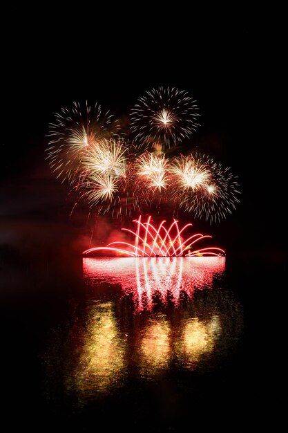 Fuochi d'artificio Bellissimi fuochi d'artificio colorati sulla superficie dell'acqua con uno sfondo nero pulito Festival divertente e concorso dei vigili del fuoco Diga di Brno Repubblica Ceca