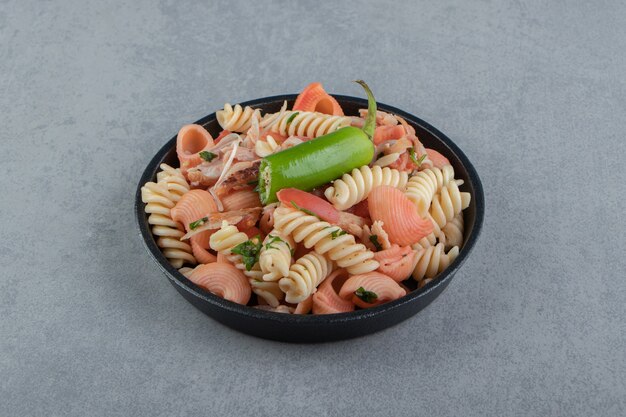 Fusilli lessati e conchiglie in ciotola nera