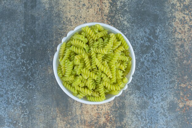 Fusilli verdi, sulla superficie di marmo.