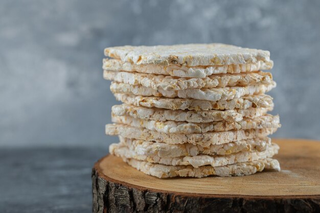 Gallette di riso secche a forma di quadrato su un pezzo di legno.