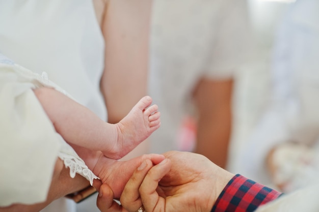 Gambe del neonato alla cerimonia del battesimo in chiesa