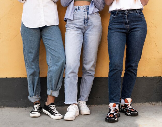 Gambe di donne davanti a un muro giallo