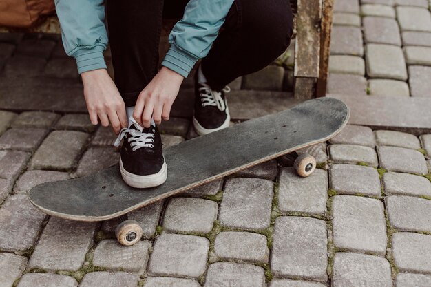 Gambe di ragazza pattinatrice in piedi sul suo skateboard