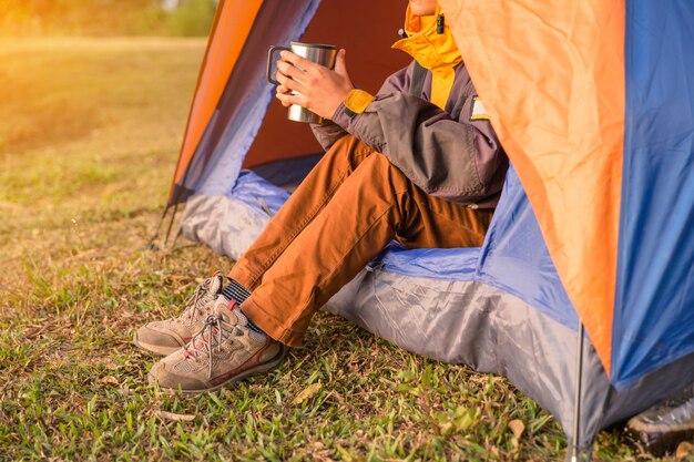 gambe visibili dalla tenda nel campeggio sullo sfondo di legno selvaggio