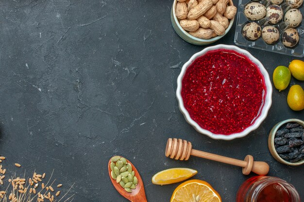 Gelatina fruttata rossa vista dall'alto con arachidi e uvetta sul biscotto di torta di pasta di noci color marmellata grigio scuro