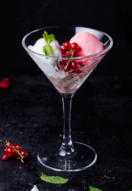 Gelato alla vaniglia e fragola con frutti di bosco, foglie di menta e cubetti di ghiaccio.