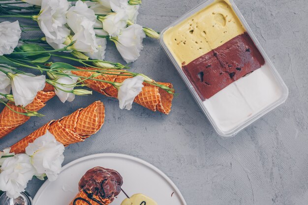 Gelato di vista superiore con i fiori su bianco