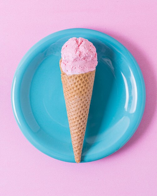 Gelato rosa minimalista sul piatto blu