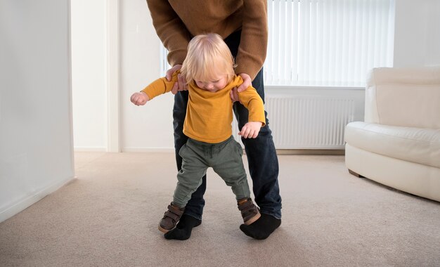 Genitore che aiuta il bambino a camminare a casa