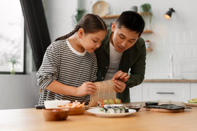 Genitore che insegna al figlio a fare il sushi