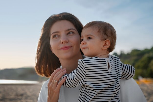 Genitore con un bambino sulla spiaggia al tramonto