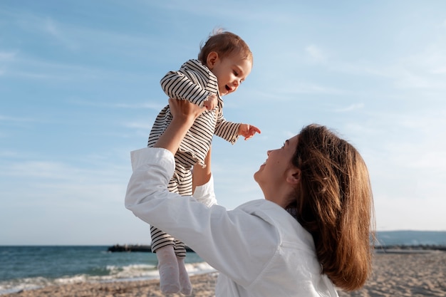 Genitore con un bambino sulla spiaggia al tramonto