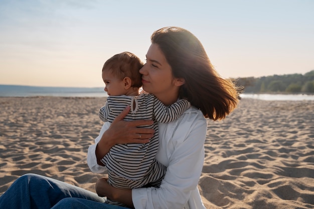 Genitore con un bambino sulla spiaggia al tramonto