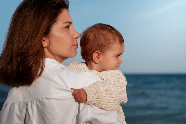 Genitore con un bambino sulla spiaggia al tramonto