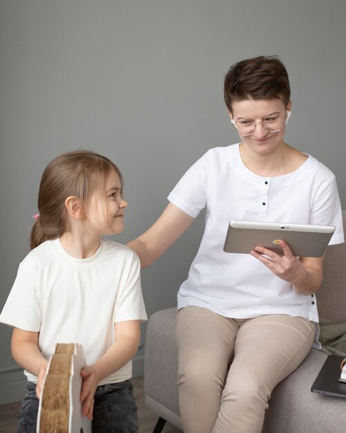 Genitore del colpo medio che lavora sul tablet