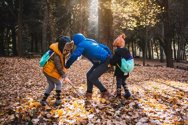 Genitore e bambini che giocano nella foresta