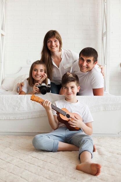 Genitore sorridente con i loro bambini che esaminano macchina fotografica