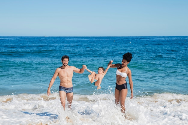 Genitori che giocano con il bambino sulla costa