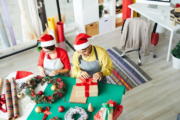 Genitori che preparano addobbi natalizi e confezionano regali