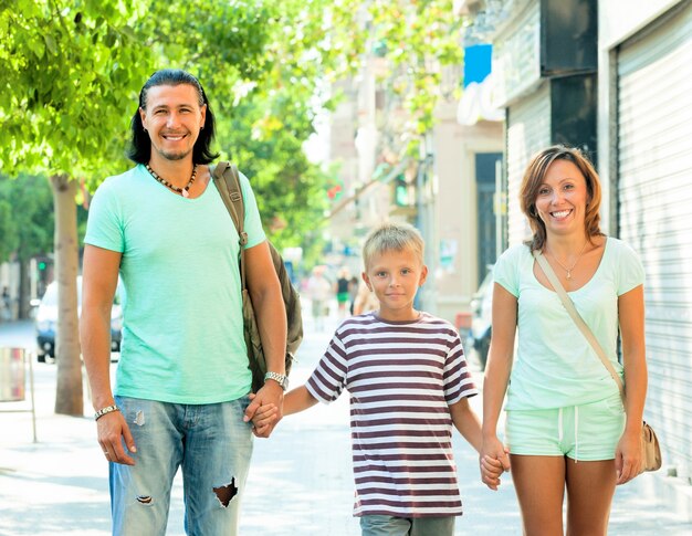 genitori con bambino che camminano in strada