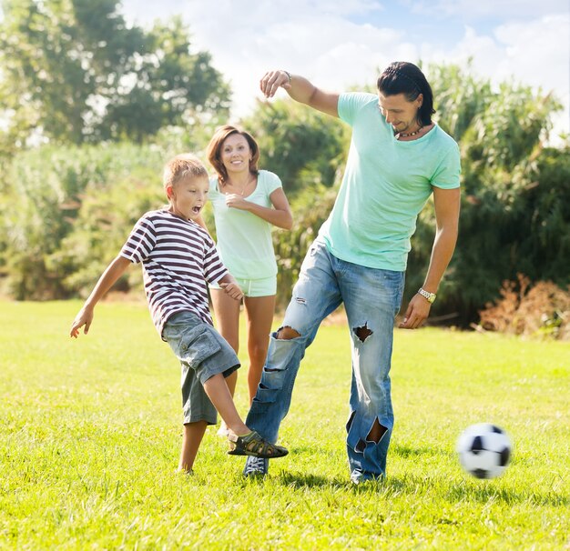 genitori con bambino che giocano con pallone da calcio