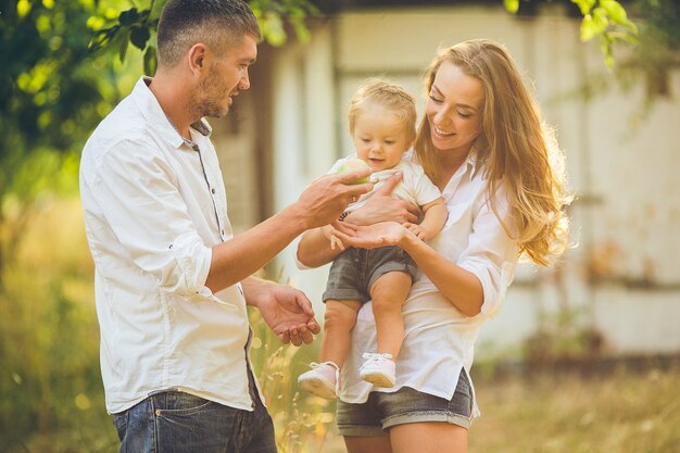 Genitori con bambino che si godono un picnic in una fattoria con mele e ciliegi.