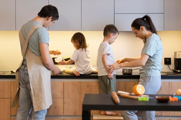 Genitori e bambini del colpo medio in cucina