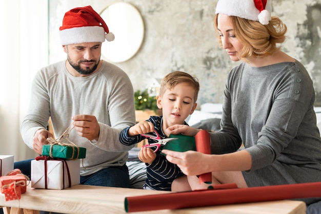 Genitori e bambino di vista frontale che stanno insieme il giorno di Natale