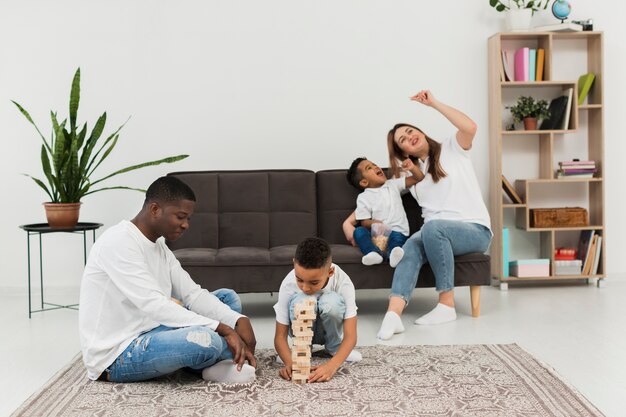 Genitori e figli che giocano insieme un gioco a torre in legno