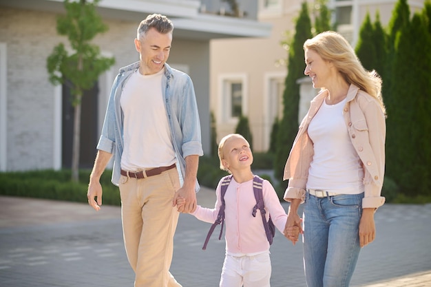 Genitori e figlia che camminano e si tengono per mano