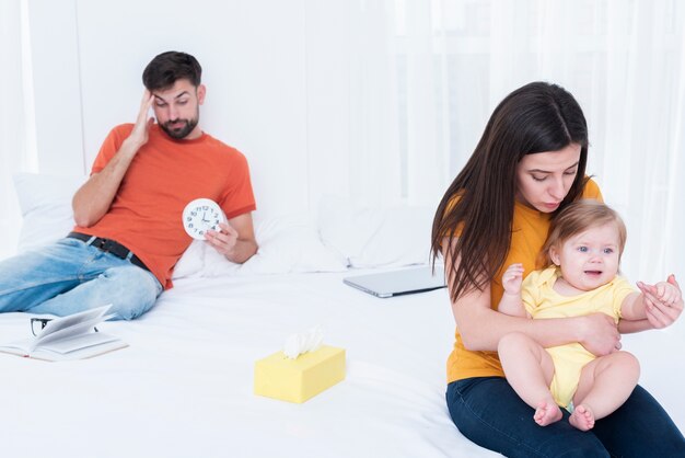 Genitori stressati mentre tengono in braccio un bambino