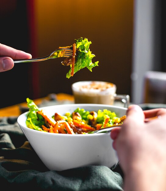 Gente che tiene gente con vista laterale insalata di mais