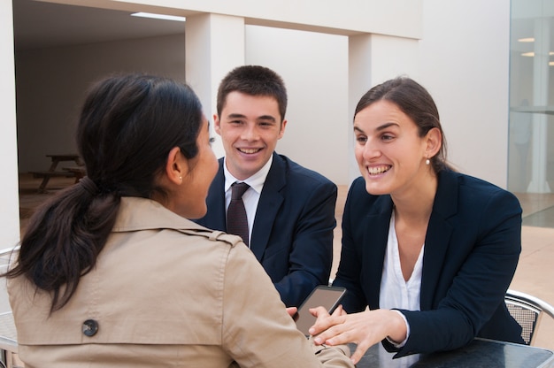 Gente di affari e cliente felici che parlano allo scrittorio all&#39;aperto