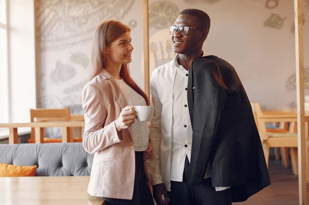 Gente internazionale in piedi in un caffè e bere un caffè