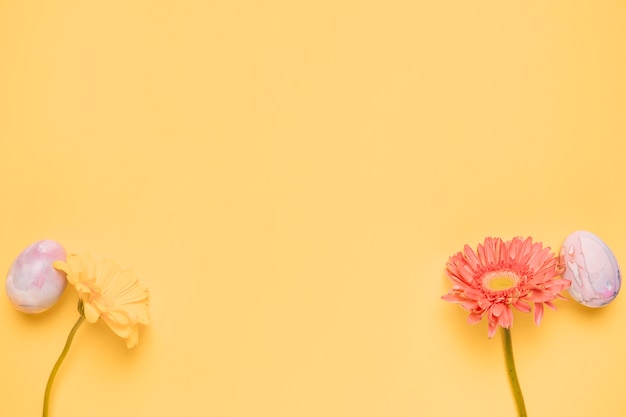 Gerbera fiore e uovo sull&#39;angolo dello sfondo giallo con copia spazio per la scrittura del testo