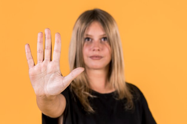 Gesto di arresto di rappresentazione defocused della donna sul linguaggio dei segni