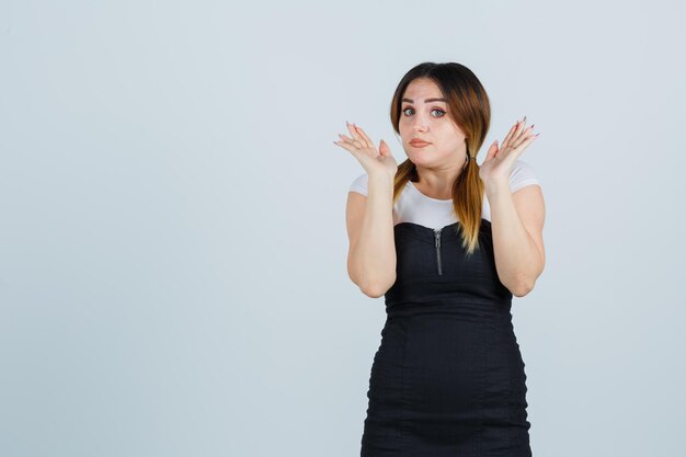 Gesto impotente della giovane donna e sguardo perplesso