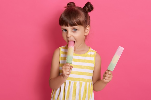 Ghiaccio d'acqua mordace della frutta mordace del bambino affascinante. Felicità e gioia della bambina che indossa l'estate, trascorrendo giorni liberi e facili d'estate.